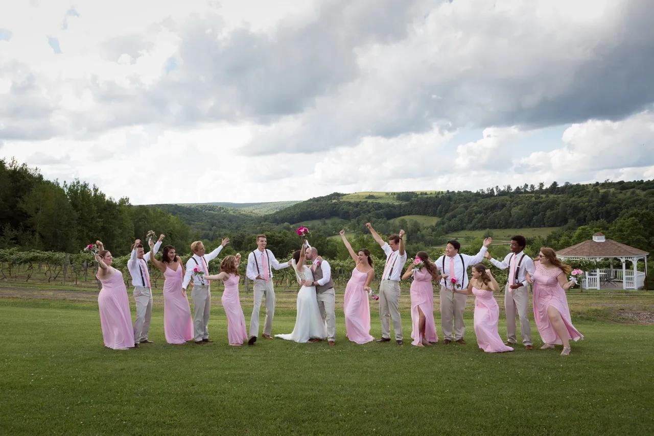 Bride, groom, and bridal party celebrating on the vineyard lawn at Starr Hill Vineyard & Winery