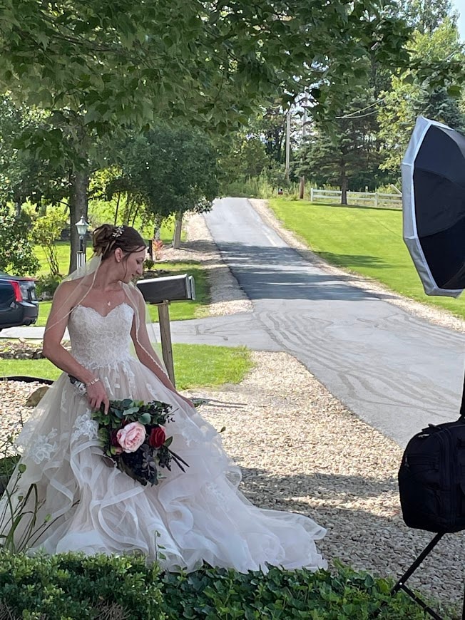 Bride in lace gown posing along the tree-lined driveway at Starr Hill Vineyard & Winery