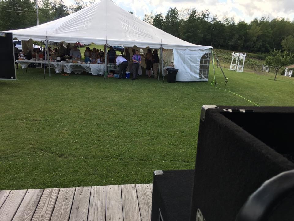 View from the DJ stage of wedding guests gathered under the reception tent at Starr Hill Vineyard & Winery